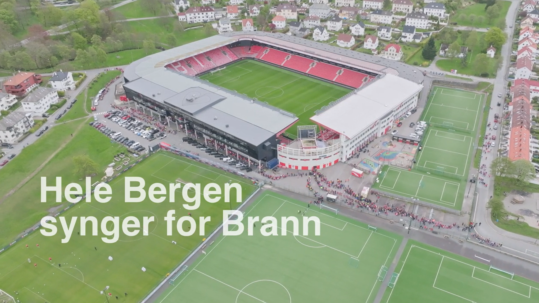 Bilde tatt ovenfra av Brann stadion, med teksten «Hele Bergen synger for Brann» plassert nederst til venstre.