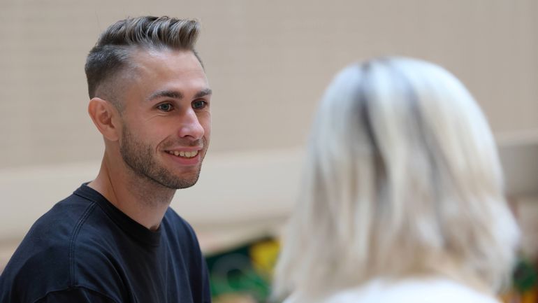 Gutt som smiler til en medstudent som har ryggen til kamera.